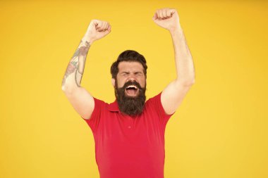 Bu bir zafer. Kaldırılmış elleri sarı arka planı olan mutlu bir hippi. Sakallı adam zaferi kutluyor. Kumar ve bahis. Zaferin tadını çıkarıyorum. Zafer ya da başarı. Kazanan ve şampiyon