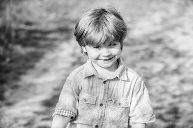 Mutlu çocuk dışarıda güneşli bir şekilde yürüyor. Bahar mevsimi. Gülümseyen küçük çocuk. İnsan ve doğa. Küçük çocuk köy tarafında dinleniyor. Toprak günü. Yaz etkinliği. çocukluk mutluluğu. Anı yaşamak