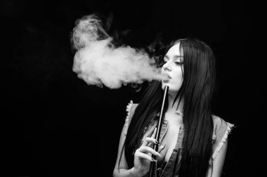 Nargile barı. Elektronik sigara. Puro içen seksi kadın. Dumanı siyah arka planda verin. Kötü alışkanlık. Kadın buharı. Sağlıksız bağımlılık. Tabacco ilacı. kopyalama alanı. Uyuşturucusuz