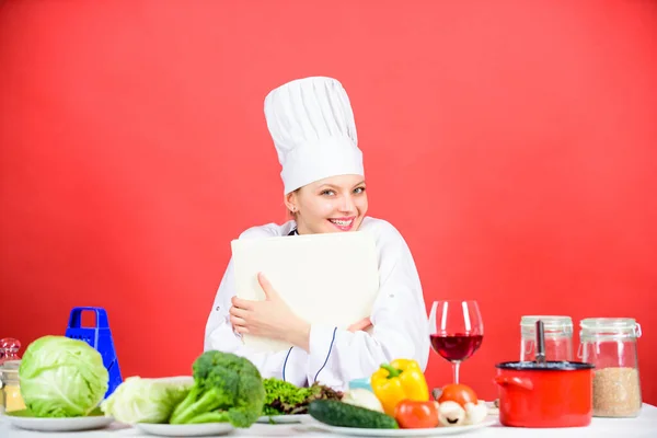 Utsökt och gourmet. Matlagning som hobby. Cook söker matlagning recept i kokbok. Kvinnan läser kokbok i köket. Flicka kock vid köksbordet ingredienser. Tips och råd. Beredning av livsmedel — Stockfoto