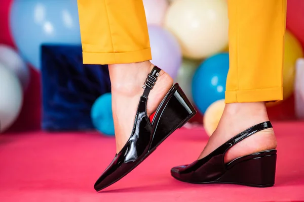 Pies femeninos en zapatos cómodos en globos de colores, viernes negro — Foto de Stock