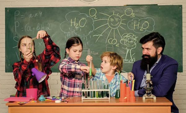 Profesores y alumnos examinan tubos en el aula. Club temático de química. Interacción grupal y comunicación. Intereses y club temático. Compartir intereses aficiones talentos y habilidades. Escuela club educación — Foto de Stock