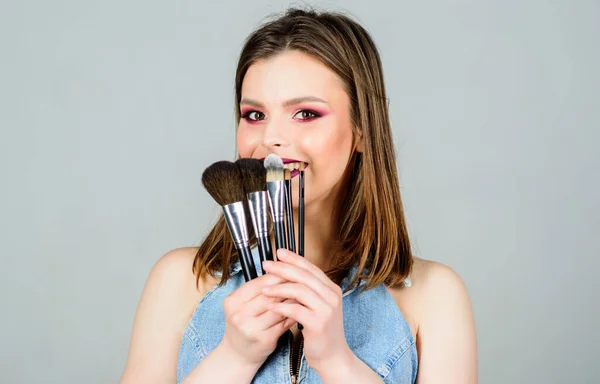 Different brushes. Makeup cosmetics concept. Skin tone concealer. Cosmetics shop. Girl apply eye shadows. Woman applying makeup brush. Emphasize femininity. Professional makeup supplies. Skin care