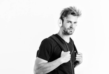 Gittiğin her yerde müziğin tadını çıkar. Müzik uygulaması indir. Gençlik müziğinin tadı. Müzik dinleyen yakışıklı öğrenci. Modern insan konsepti. Saç stili değiştirilmiş adam plastik kulaklık takıyor.