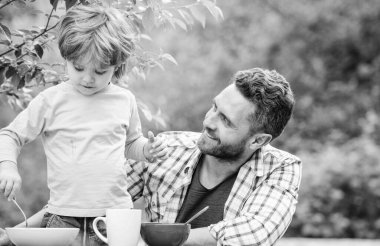 Sağlıklı yemek ve diyet. Çocuklar Günü 'nde. Yaz pikniği. Sabah kahvaltısı. Baba oğul dışarıda yemek yiyorlar. Babalar günün kutlu olsun. Babasıyla küçük çocuk mısır gevreği yiyor. Aile yemeği zamanı. Mutlu bir aile olduğumuz için