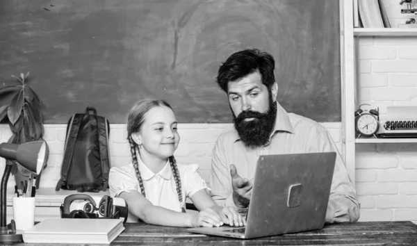 Study modern technologies. School teacher and schoolgirl with laptop. Man bearded pedagogue teaching informatics. Homeschooling with father. Find buddy to help you study. Private lesson. Study online