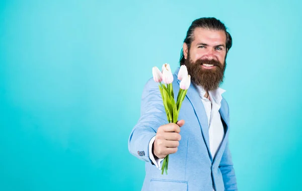 This is for you. hipster man hold tulip flowers. gift for romantic date. bearded man in elegant jacket hold flowers. wedding day. happy fathers day. mature bride groom with bouquet