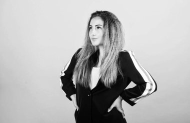 Zarif ve atletik parçaları karıştırıyorum. Spor kıyafetleri podyumlarda kural koyuyor. Voluminous kıvrımlı saç stili. Moda kıvrımlı saç stili. Şık spor. Mavi arka planda kadın saç stili. Moda eğilimi