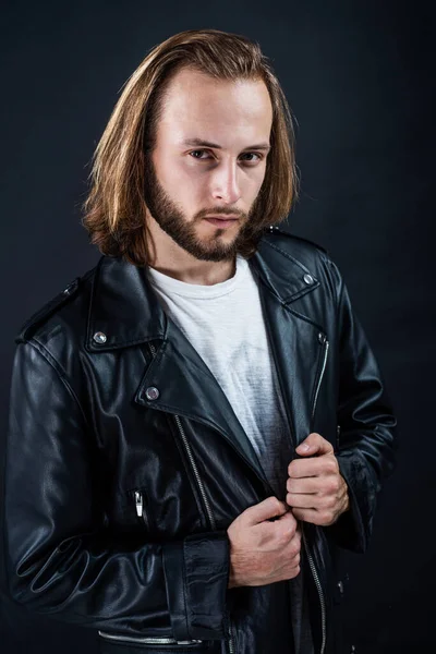 biker. bearded rocker in leather jacket. man with long hair. rock style fashion.