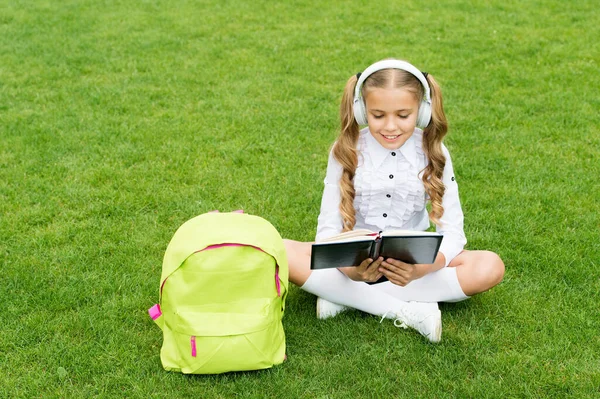 Sprachkurs. Mädchen lernen Englisch sitzend auf grünem Gras. Fremdsprache. Audio-Unterricht — Stockfoto