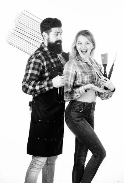 Cocinando juntos. Herramientas para asar carne al aire libre. Picnic y barbacoa. hipster barbudo y chica listo para la fiesta de barbacoa. Asar y asar alimentos. Pareja en el amor mantenga utensilios de cocina barbacoa — Foto de Stock