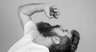 Taze meyve suyu konsepti. Hippi sakallı meyve suyu şişesi gibi çilekleri avucunun içinde tutuyor. Sakallı adam çilek suyu içer. Katı yüzlü adam ekstra taze çilek suyunun keyfini çıkar.