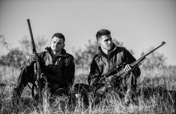 Cazadores con rifles relajantes en ambiente natural. Caza con amigos ocio hobby. Los amigos cazadores disfrutan del ocio. Cazadores satisfechos con la bebida de calentamiento de captura. El descanso para los hombres reales concepto — Foto de Stock