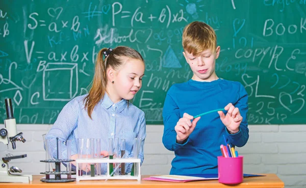 Estudiantes inteligentes de niñas y niños llevan a cabo experimentos escolares. Educación escolar. Análisis químico. Niños ocupados estudiando química. Lección de química escolar. Laboratorio escolar. Describir el bloc de notas de reacción química — Foto de Stock