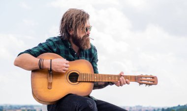 Tişörtlü, beyaz, vahşi hippi akustik gitar çalıyor, şarkıcı.