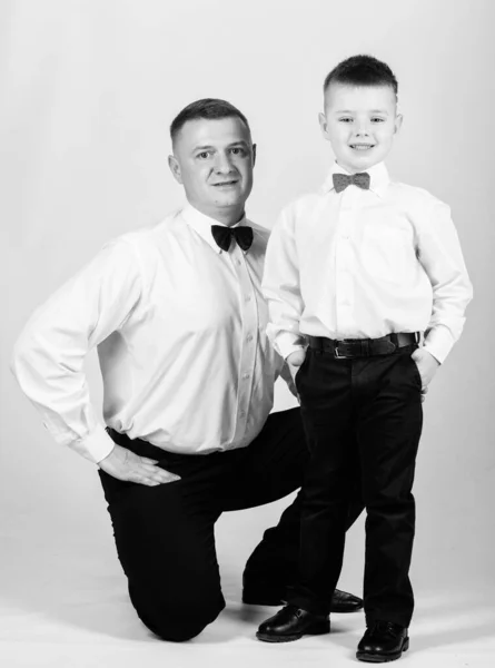 La educación de los caballeros. Evento formal. Hijo pequeño siguiendo el ejemplo de los padres de un hombre noble. La educación de los caballeros. Traje de ropa formal de padre e hijo. Crecer caballero. Papá y niño con pajaritas — Foto de Stock