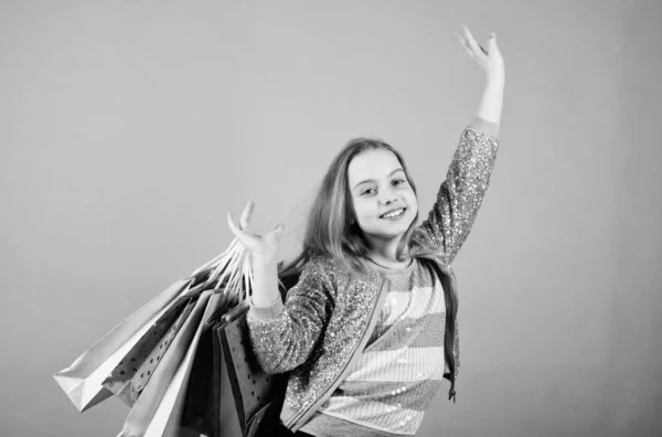 Centro comercial. Ahorro de compra vacaciones. Ir de compras. Ventas y descuentos. Moda infantil. asistente de tienda con paquete. Niña pequeña con bolsas de compras. Feliz niña. Niña con regalos. cliente en el centro comercial —  Fotos de Stock