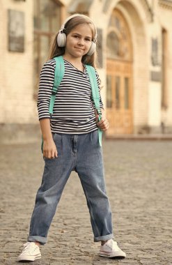 Seyahat etmek öğrenmek demektir. Küçük çocuk dışarıda müzik dinleyerek seyahat çantası taşıyor. Eğitim gezisi. Turizm eğitimi. Okul tatili. Yaz tatili. Seyahat ve seyahat. Macera bizi bekliyor.
