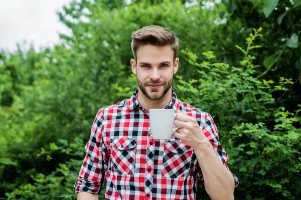 체크무늬 셔츠를 입은 잘생긴 청년은 아침에 커피를 마십니다. — 스톡 사진
