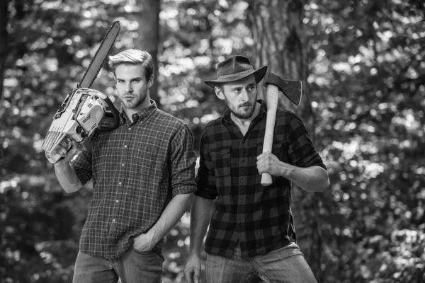 Tiempo libre juntos. actividad de verano o primavera. hombre agricultores relajarse en el bosque. Los guardabosques usan equipos. Madera con motosierra y hacha. Cosecha leña. senderismo en madera profunda. cuidado forestal en vacaciones — Foto de Stock