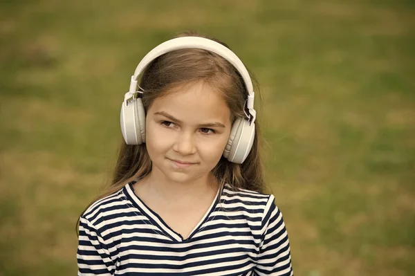 Enfrenta a música. Menina ouvir música ao ar livre. Pequena criança usa fones de ouvido tocando música. Nova tecnologia. Vida moderna. Férias. Diversão e entretenimento. Ouçam. — Fotografia de Stock