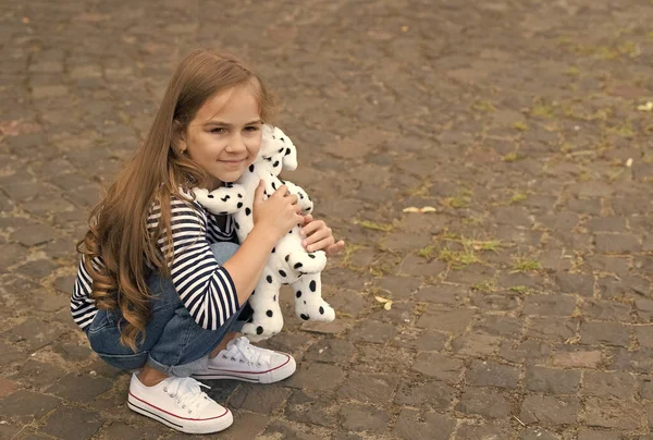 Ты мой друг. Маленькая девочка играет с игрушечной собакой на открытом воздухе. Маленький ребенок наслаждается дружбой. Детская дружба. Развитие навыков общения. Международный день дружбы. Любовь и доверие, копирование пространства — стоковое фото