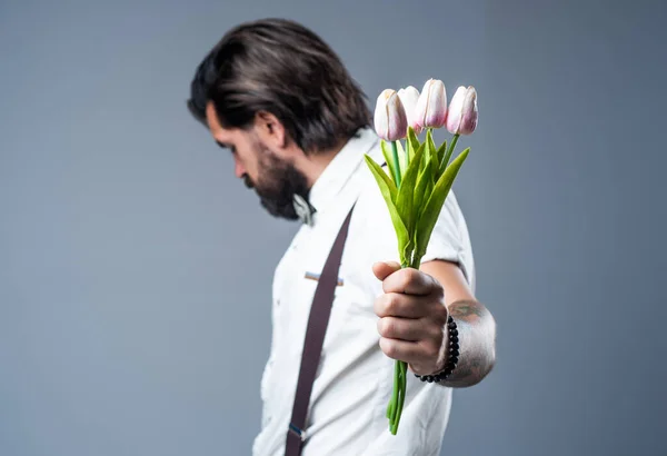 Invertire gli occhi uomo portare tulipano regalo di fiori per San Valentino o festa di compleanno, festa della mamma — Foto Stock