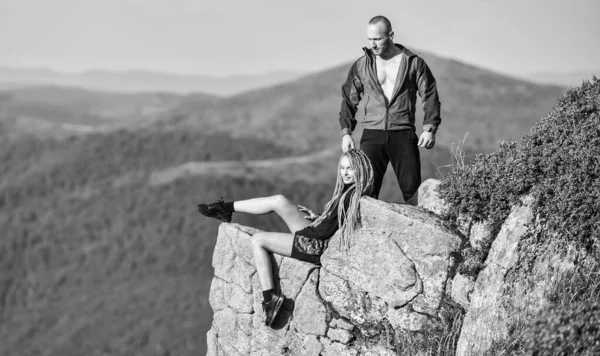 カップルのハイカーは景色を楽しむ。ハイキングの利点。ハイキングの週末。世界の果てだ。女性の崖の高い山の風景の背景の端に座る。平和な瞬間をハイキング。観光ハイカーの女の子と男リラックス — ストック写真