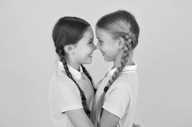 Dostça sarılalım. Sevimli liseli kızlar. Saç stili örülmüş kızlar. Neşeli liseli kızlar sarı arka planda. Şirin örgülerle oynayan küçük kızlar. Güzel liseli kızlar en iyi arkadaşlar. Okul konseptine dönelim.