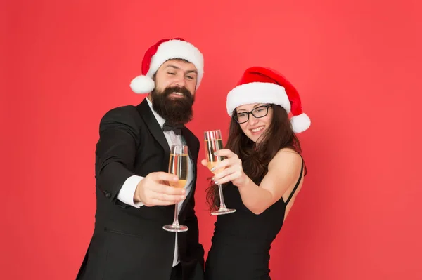Új év, új célok. üzletember és lány pezsgőt isznak. Karácsonyi buli. A szerelmesek ünnepelik az új évet. szmokingos férfi női télapósapkával. Boldog karácsonyt és éljenzést mindenkinek! — Stock Fotó