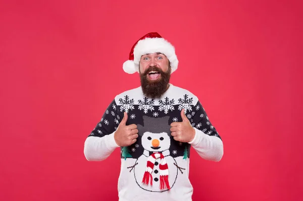 Listo para las vacaciones. moda de ropa caliente de temporada. listo para el año nuevo. Feliz navidad. hombre barbudo feliz sombrero de santa rojo. alegre hipster favorito divertido suéter con muñeco de nieve. vacaciones de invierno diversión — Foto de Stock