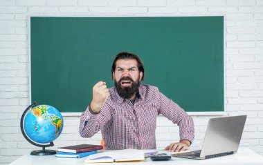Sınavı geç. Öğrenmek zordur. Stresli hippi öğretmen. Aşırı çalışan, sakallı, stresli bir adam. Çalışmada sorunlar. resmi eğitim. Erkek öğrenci zor bir ders sırasında sınıfta oturuyor.