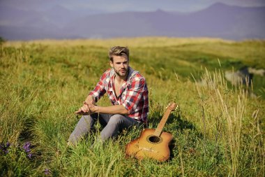 Gitarlı adam doğayı düşünüyor. İlham verici bir doğa. Tek başına iyi vakit geçirdin. İlham arayan bir müzisyen. Hayalperest gezgin. Seyahat tutkusu konsepti. Yaz tatili doğada var. Huzurlu ruh hali
