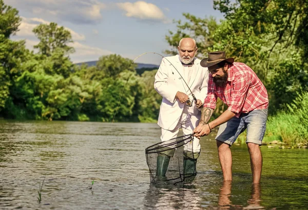 Felizes pescadores amizade. Conceito de captura e pesca. Dois amigos a pescar juntos. pai reformado e filho barbudo. passatempo de peixe de mosca de homem de negócios. pesca da reforma. Família feliz juntos — Fotografia de Stock