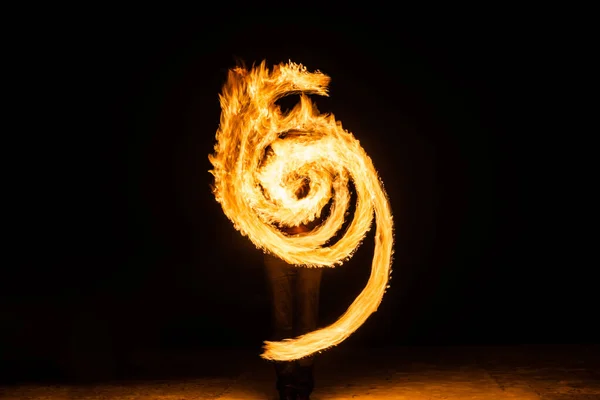 Ateş sanatçısı gece karanlığında ateşli dairesel kavisler sergiliyor, Fibonacci spirali — Stok fotoğraf
