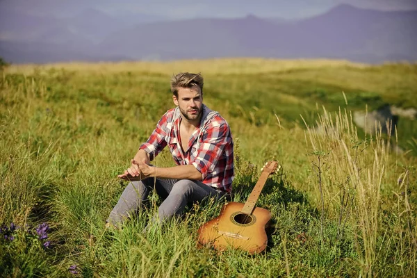 Um tipo com guitarra contempla a natureza. Inspirando a natureza. Diverte-te sozinho. Músico à procura de inspiração. Vagabundo sonhador. Conceito de luxúria. Verão férias highlands natureza. Humor pacífico — Fotografia de Stock