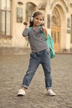 Macera orada bir yerde. Küçük gezgin parmağını ileri uzat. Küçük çocuk sırt çantasıyla müzik dinliyor. Çocukluk macerası. Macera tatili. Tatil gezisi. Seyahat ve seyahat tutkusu. Zihnini boşalt