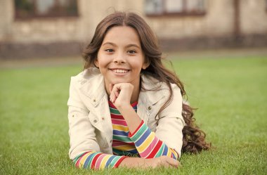 Keyfim yerinde. Okula dönüyorum. Küçük kız günlük kıyafetler giyer. Güzellik ve moda. Parktaki güzel öğrenci kız. Şirin, kendine güvenen liseli kız yeşil çimlerde rahatlıyor. Mutlu çocukluk