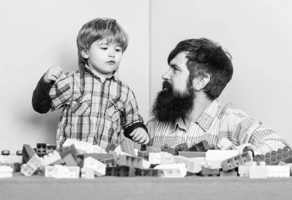 Papá y el niño construyen bloques de plástico. Desarrollo del cuidado infantil. De ocio familiar. Padre e hijo crean construcciones. Barbudo e hijo juegan juntos. Formas seguras de vincularse con su hijo. Padre hijo juego —  Fotos de Stock