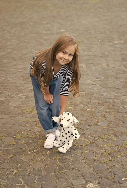 遊びは簡単な喜びです。屋外でおもちゃの犬と幸せな赤ちゃんの遊び。子供の発達。ゲームや活動。友人や友情。おもちゃ屋さん。遊びを通して学ぶ — ストック写真