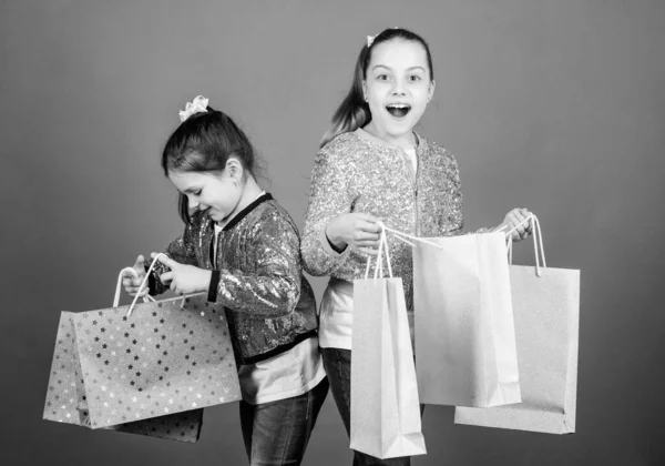 Día de compras. Paquetes de niños. Moda infantil. Chicas hermanas amigas con bolsas de compras fondo violeta. Porque la imagen es todo. Compras y compras. Viernes Negro. Venta y descuento —  Fotos de Stock