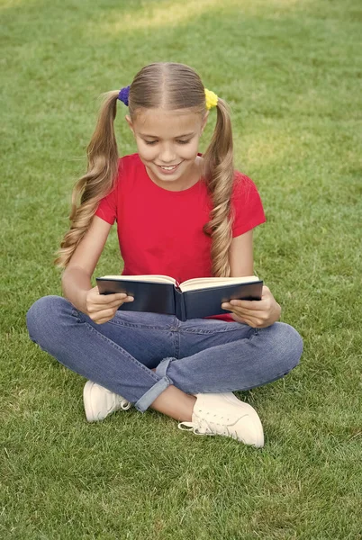 Me encanta leer. Lector feliz verano al aire libre. Un niño leyó un libro sobre hierba verde. Lista de lectura de verano. Fantasía y ficción. Literatura y poesía. Un chico que lee. Vamos a leer — Foto de Stock