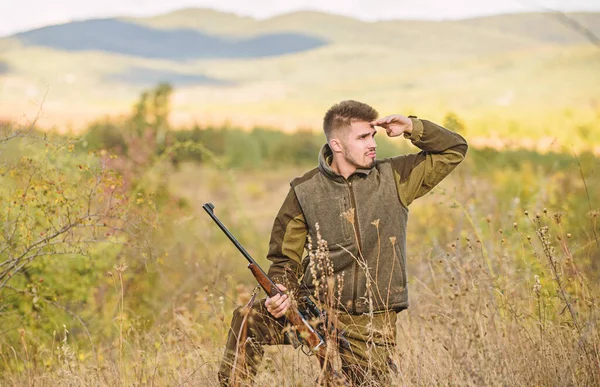 Hunter hold rifle. Focus and concentration of experienced hunter. Hunting and trapping seasons. Man brutal gamekeeper nature background. Hunting permit. Bearded hunter spend leisure hunting
