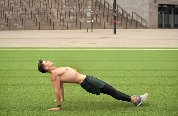 Uomo Sportivo Fare Esercizio Plank indietro. Un tizio con la tavola inversa. Yoga fitness uomo stretching corpo in posizione di plancia verso l'alto. facendo esercizio di fasciatura inversa all'aperto sull'erba del parco. forza corporea totale — Foto Stock