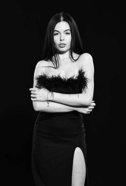 Siyah mükemmel. Göz kamaştırıcı bir tarz. Tüy süslemeleri. Zarif kadın model. Tüylü elbise giyen şık bir kız. Süslü kıyafetler. Moda dükkanı. Moda konsepti. Basitlikte zarafet