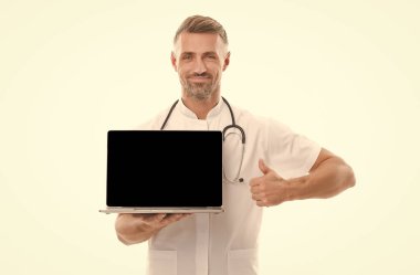 Laptoplu erkek terapist. Steteskoplu bir tıp çalışanı başparmağını kaldırdı. Modern tıptaki teknoloji. İnternetten doktordan randevu al. Covid 'de doktor konsültasyonu. Kişisel hesabınız