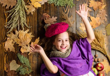 Sonbahar moda şapka aksesuarı. Moda modası sonbahar sezonu. Kız, ahşap arka planda düşmüş akçaağaç yaprakları üzerinde yatıyordu. Şapka aksesuarları. Parlak, yumuşak şapkalı kız Sonbaharın tadını çıkar