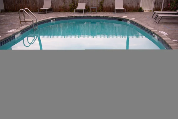 Palmeiras refletidas na água da piscina com espreguiçadeiras em villa no resort tropical de Miami, na Flórida, EUA — Fotografia de Stock