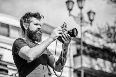 Elle ayarlar. Fotoğrafçı klasik fotoğraf makinesini tutar. Modern blogcu. İçerik yaratan. Sakallı hippi fotoğrafçı. Sakallı ve bıyıklı bir fotoğrafçı. Uzun sakallı bir adam fotoğraf çekiyor.