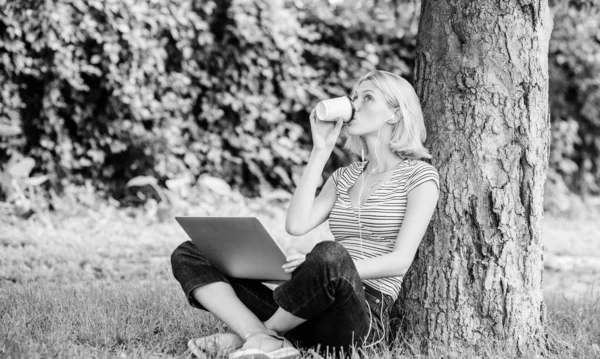 Flicka arbeta med bärbar dator i parken. Lunch tid koppla av eller kaffe paus. Jobba i sommarparken. Skäl till varför du ska ta ditt arbete utanför. Naturen är nödvändig för välbefinnande och förmåga att vara produktiv — Stockfoto